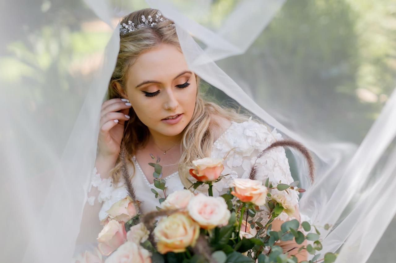 Beautiful bride with veil and bouquet, professional makeup by Debi Tollman