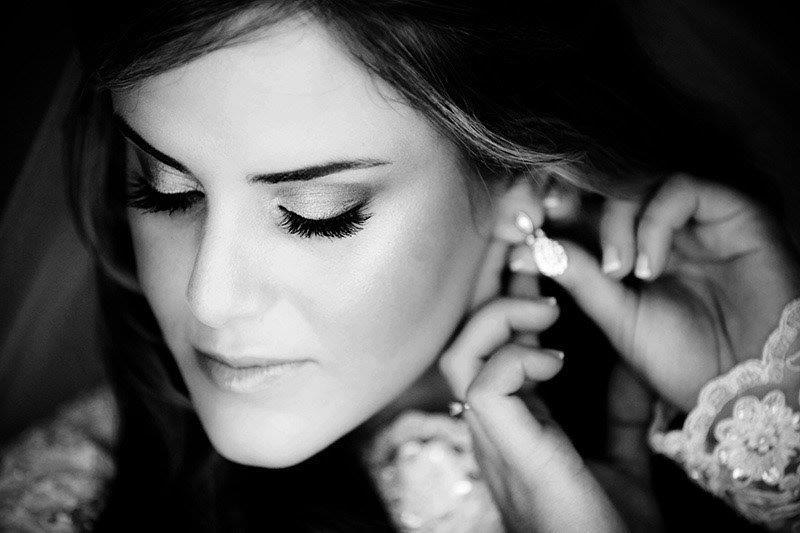 Bride getting earring put on, lace detail
